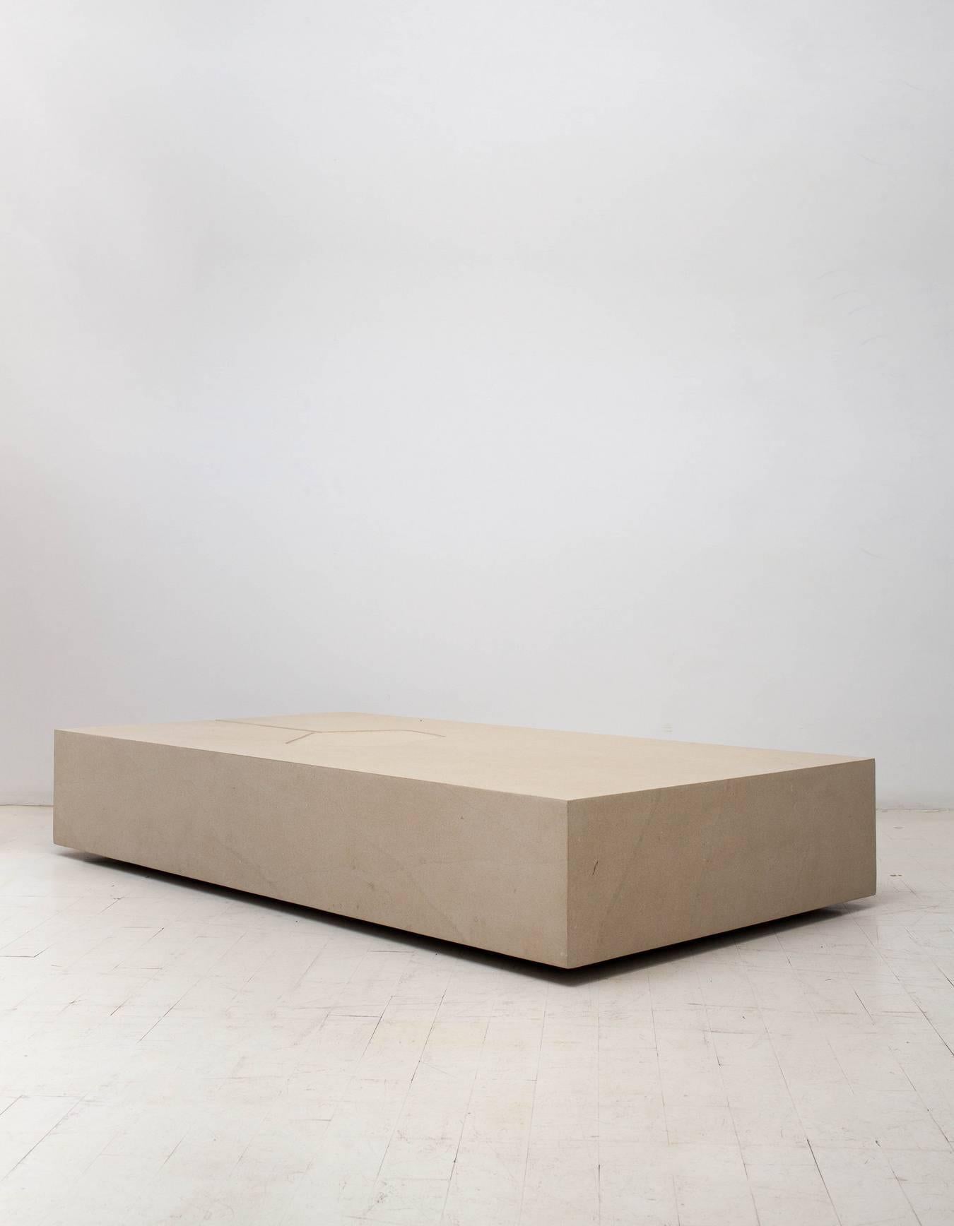 Clareira coffee table by Brazilian designer Claudia Moreira Salles

The Clareira coffee table is a rectangular box made of 5 stone slabs. The top surface is carved with an engraving reminiscent of a path and clearing, giving way to its name,