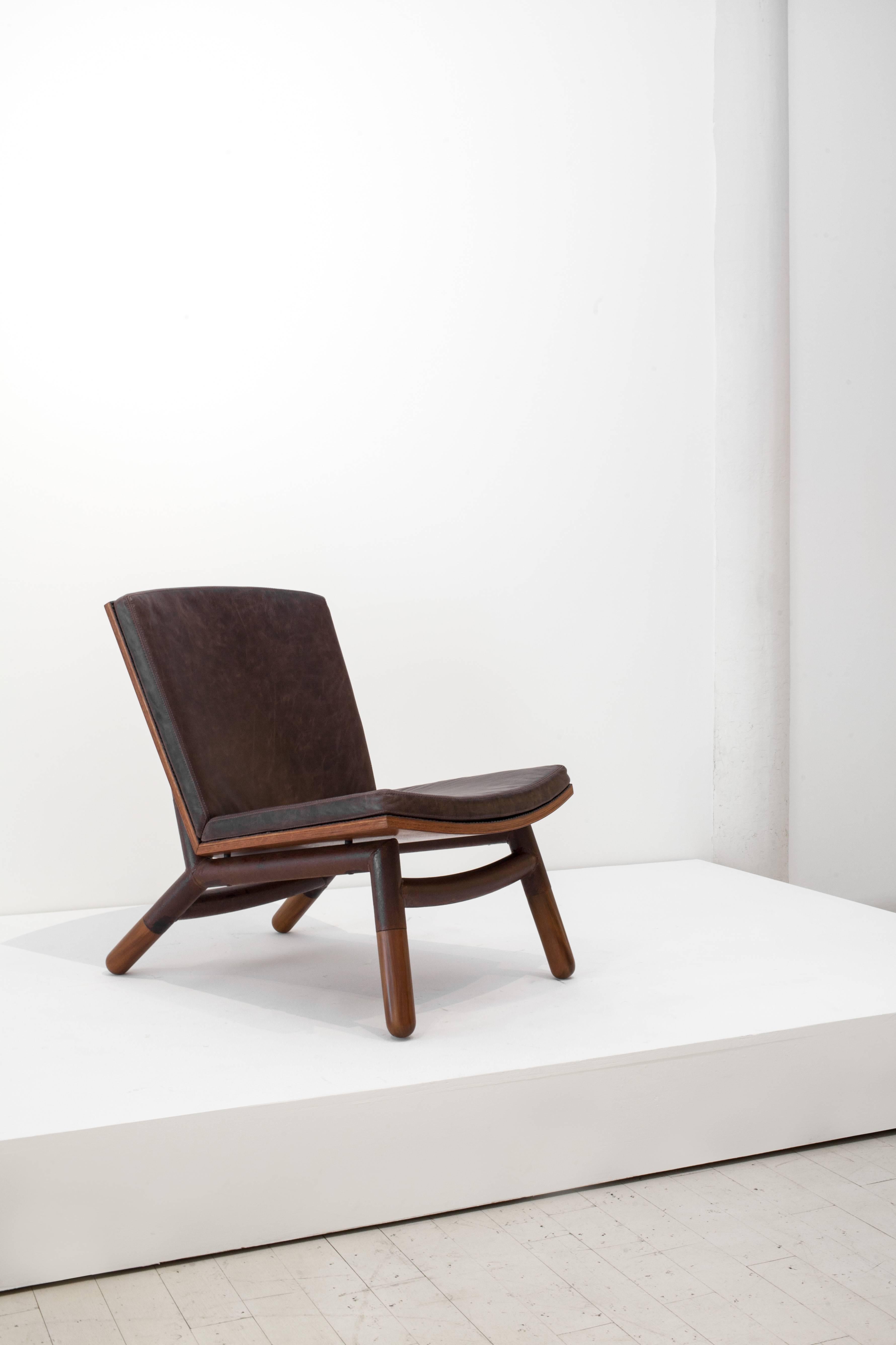 A recent Carlos Motta design, the ultra-comfortable Java chair is made from reclaimed Peroba Rosa wood molded laminates, oxidized iron and leather upholstery complete with brass nails. Combining a rustic and clean design, the Java is representative