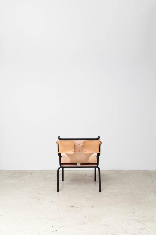 The “Bola de Latao” chair features a striking design with each front leg capped with a brass sphere at the top and soft leather wrapped around a tubular iron structure and stretched using ties. It was produced only as a limited run of six for Bo