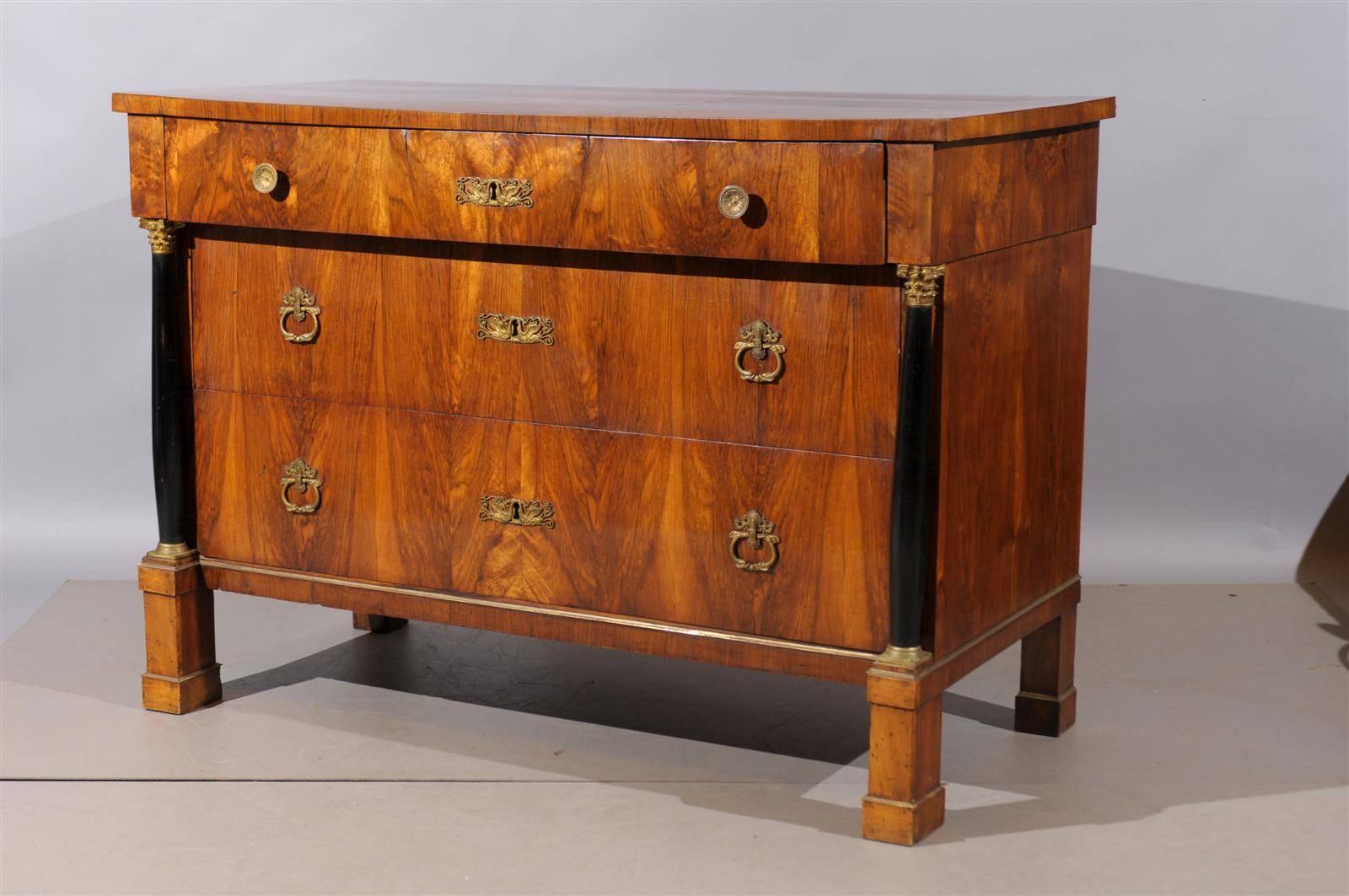 Pair of large early 19th century Italian Empire walnut commodes with ebonized columns, bronze doré hardware, and three drawers.