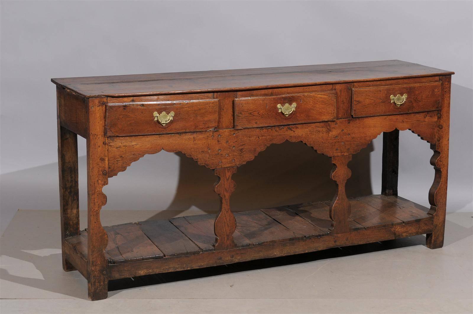 Early 19th century English oak dresser base / server with three drawers and lower plinth base.
