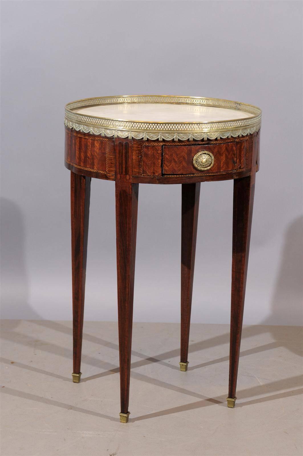 19th century French Louis XVI style tulipwood inlaid bouillotte table with white marble top and brass gallery.