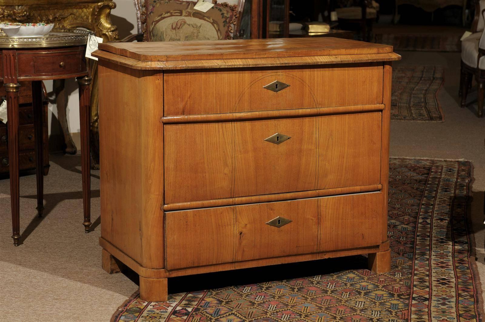 19th century petite Biedermeier commode in ash with three drawers and ebonized detail.