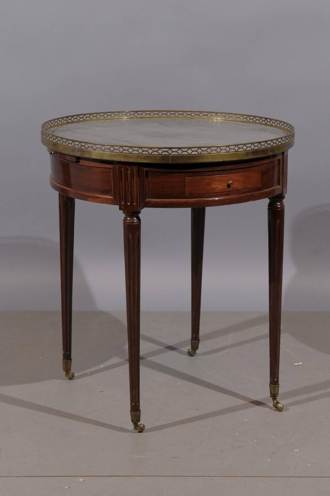 Louis XVI style mahogany French bouillotte table with grey marble top, brass gallery, drawer and two candle slides. 

William word fine antiques: Atlanta's source for antique interiors since 1956.