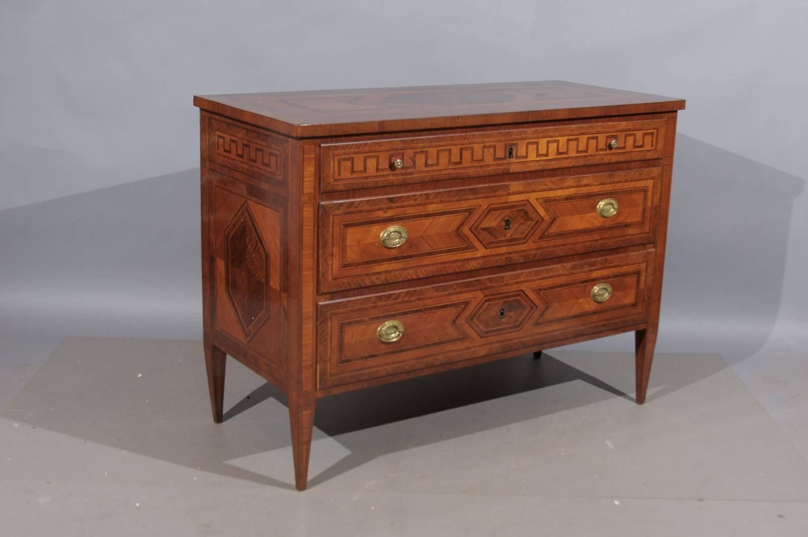 A pair of early 19th century Italian neoclassical style inlaid walnut commodes with Greek key inlay.