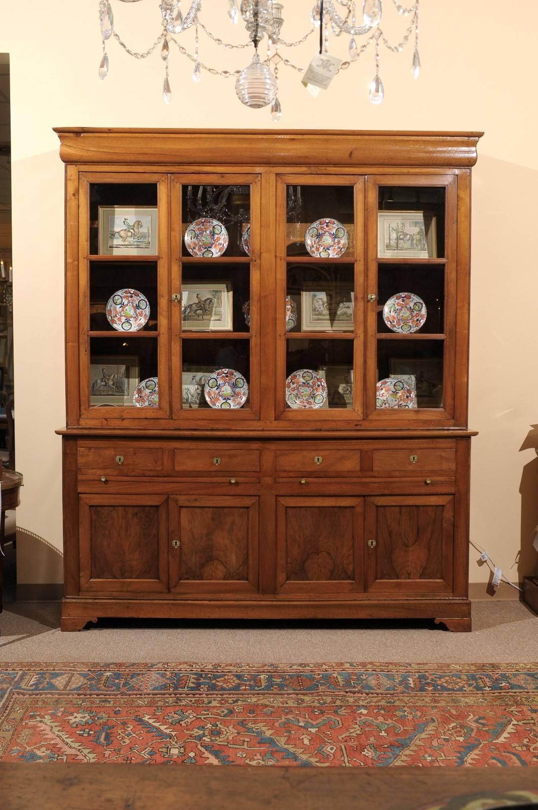 19th century French Louis Philippe walnut bookcase with four glass panel doors, four drawers and cabinet below.
    
   
