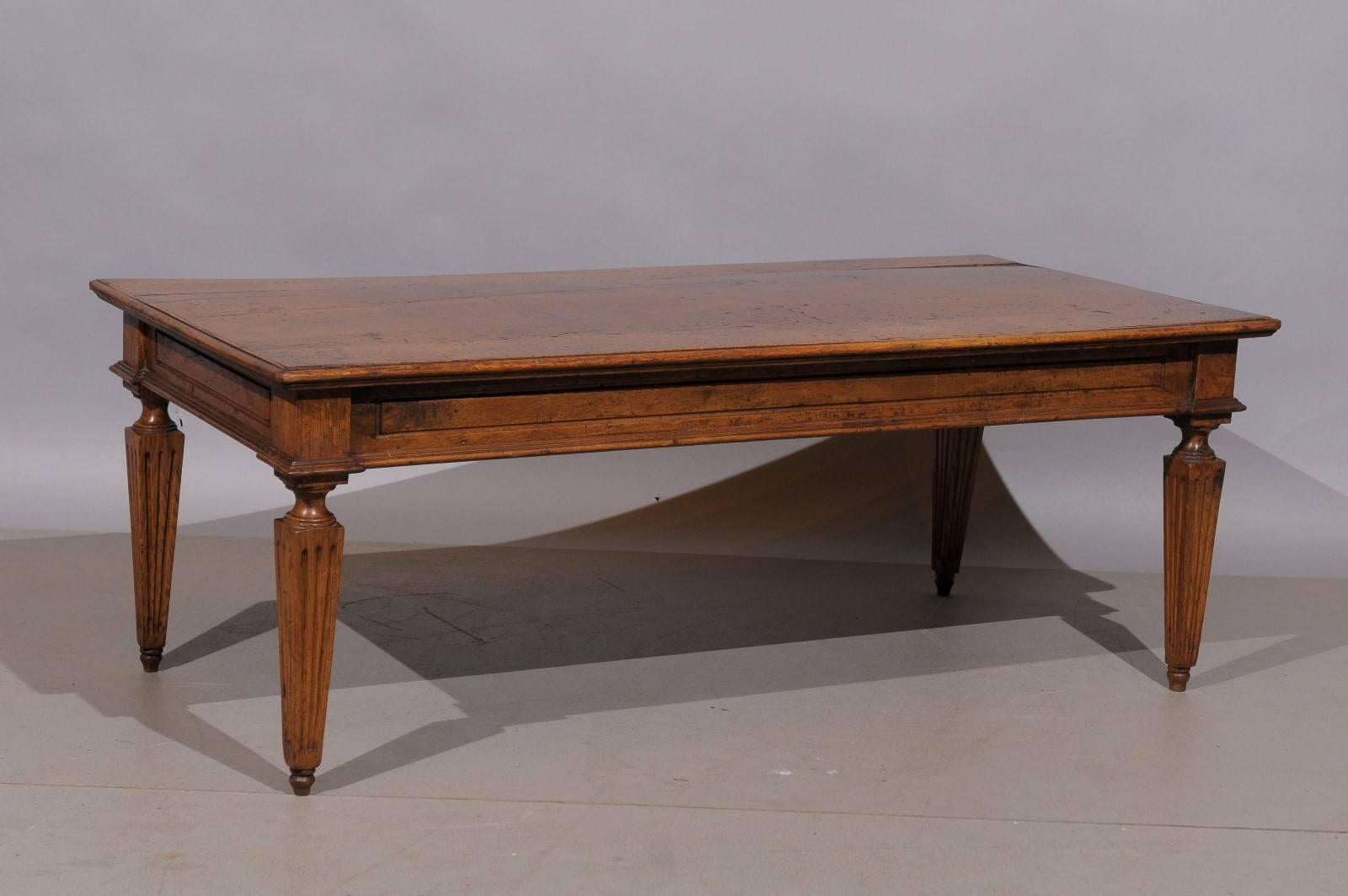 An Italian neoclassical style walnut coffee table with fluted carved tapered legs.
   
   
