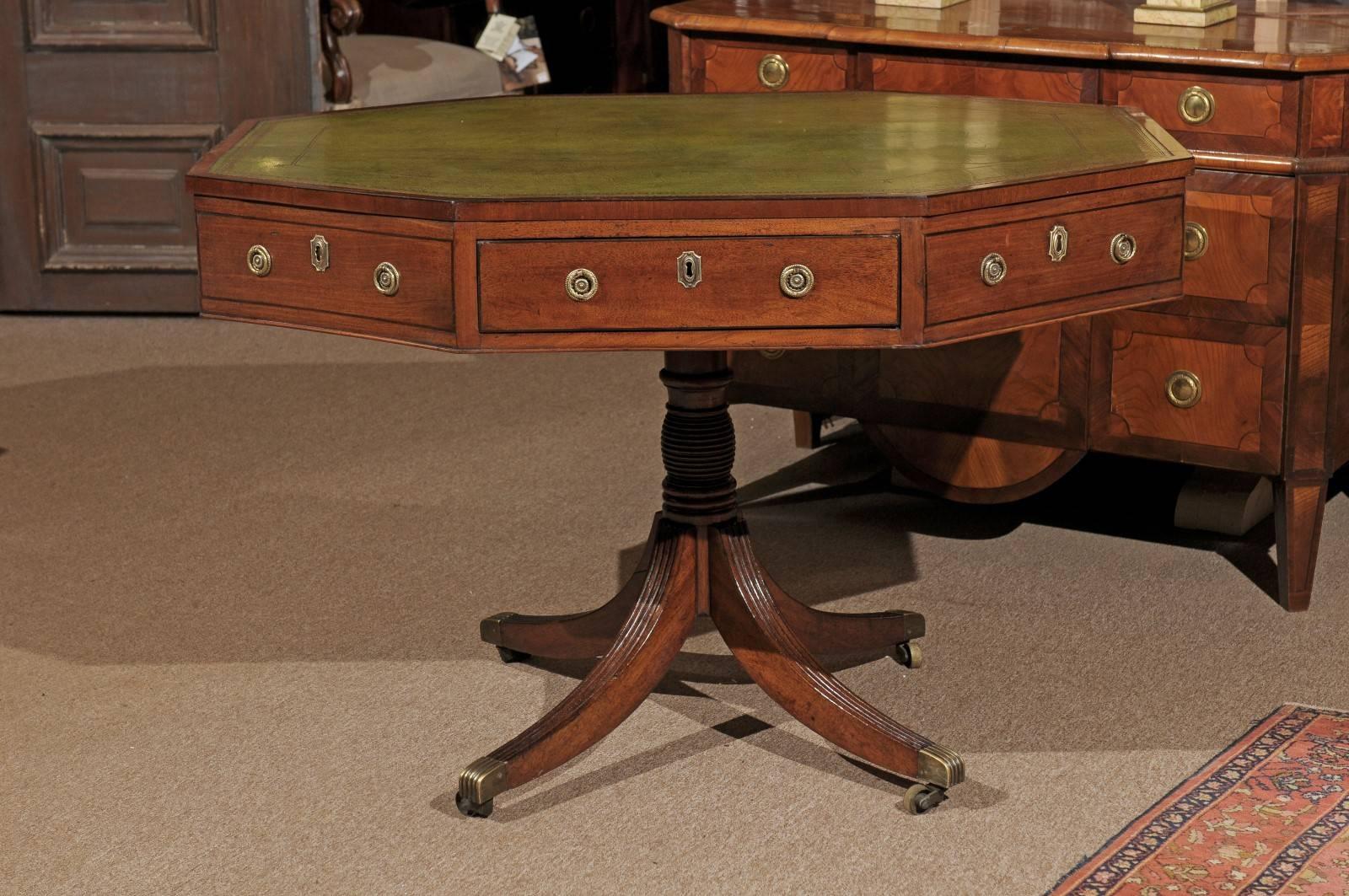 Early 19th century English Regency octagonal mahogany rent table with green leather top, reeded pedestal base, and splay legs.