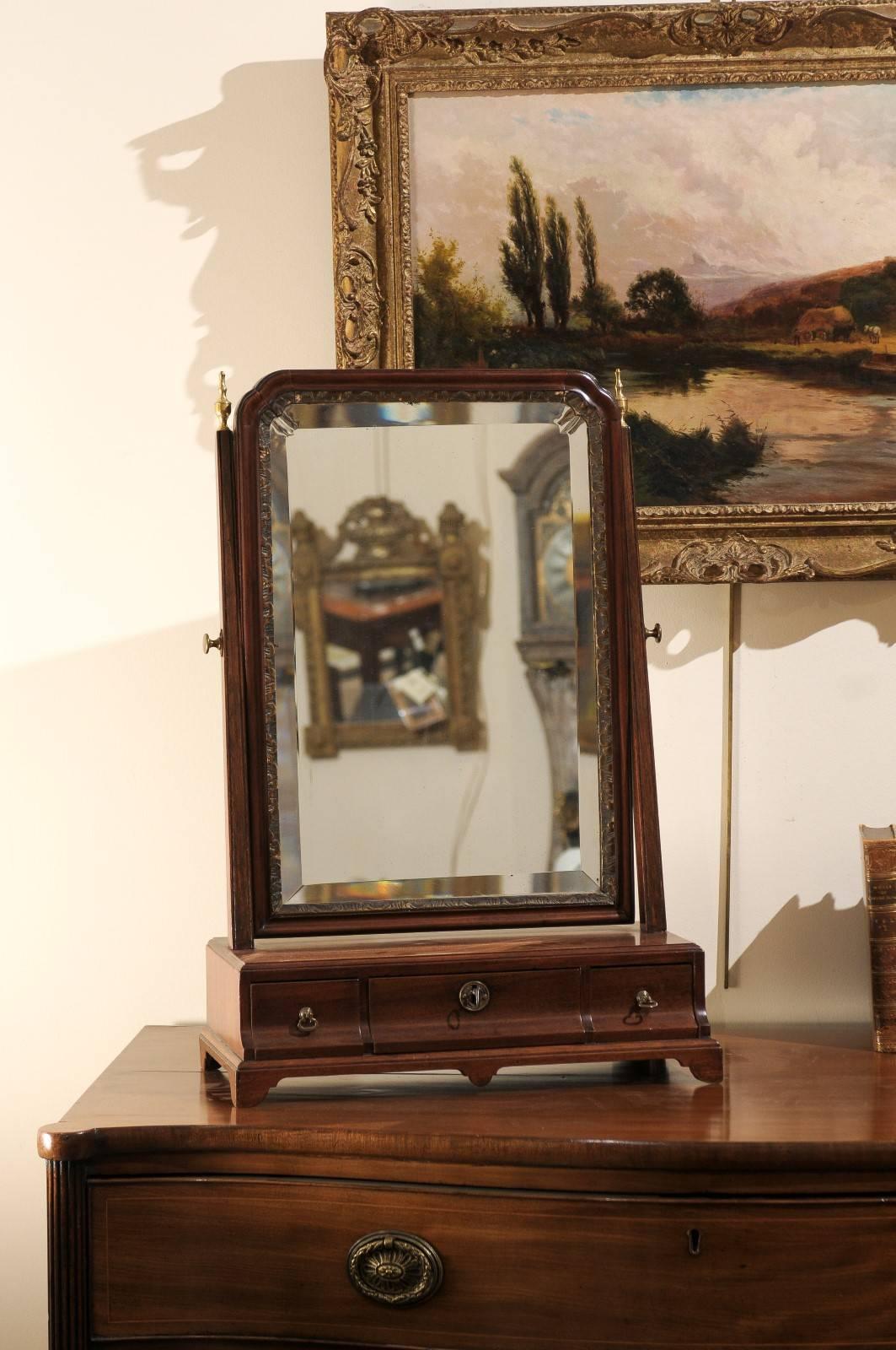 A late 18th century English George III mahogany shaving mirror attached to base with 3 drawers ending in bracket feet.