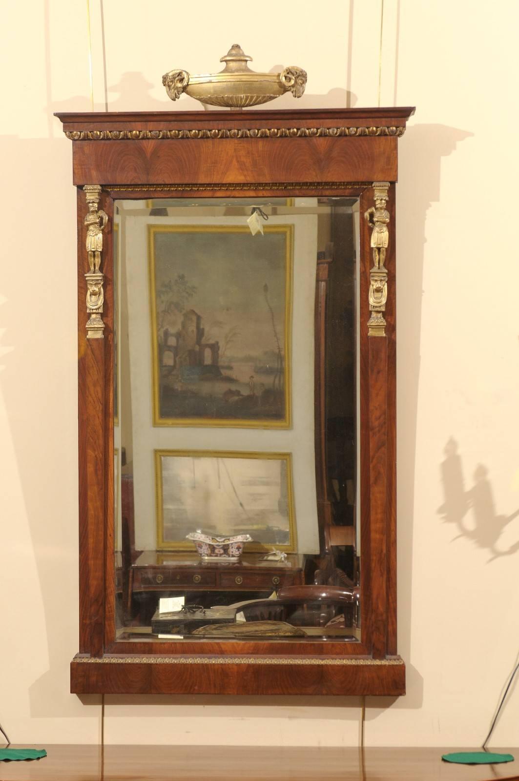 Empire period mahogany mirror with urn motif and gilt accents, France, circa 1810.