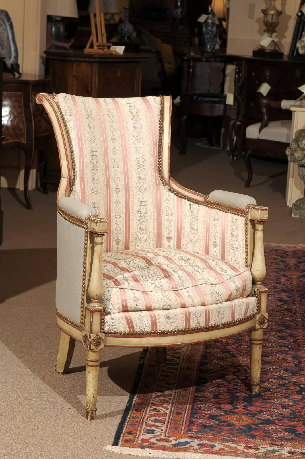 19th century French Directoire bergere chair in cream colored painted finish with rusty red accents.