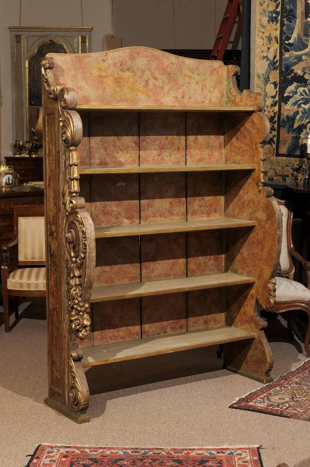 Spanish Rococo style giltwood and polychrome painted open shelf bookcase with five shelves and intricately carved side panels, 20th century.