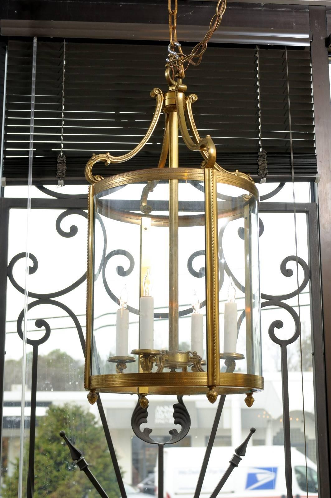 Mid-20th century French Louis XVI style round brass lantern with four (4) lights and acorn finials.