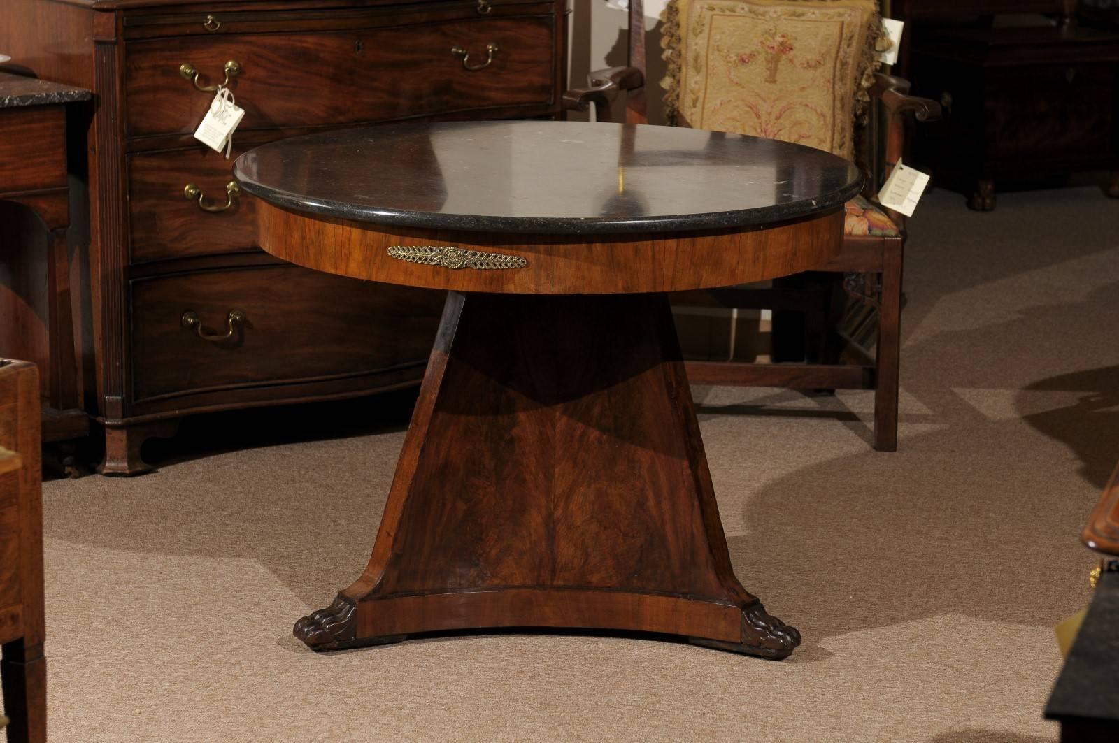 Walnut Empire period center table with paw feet and bronze doré mounts and grey marble top, France, 19th century.