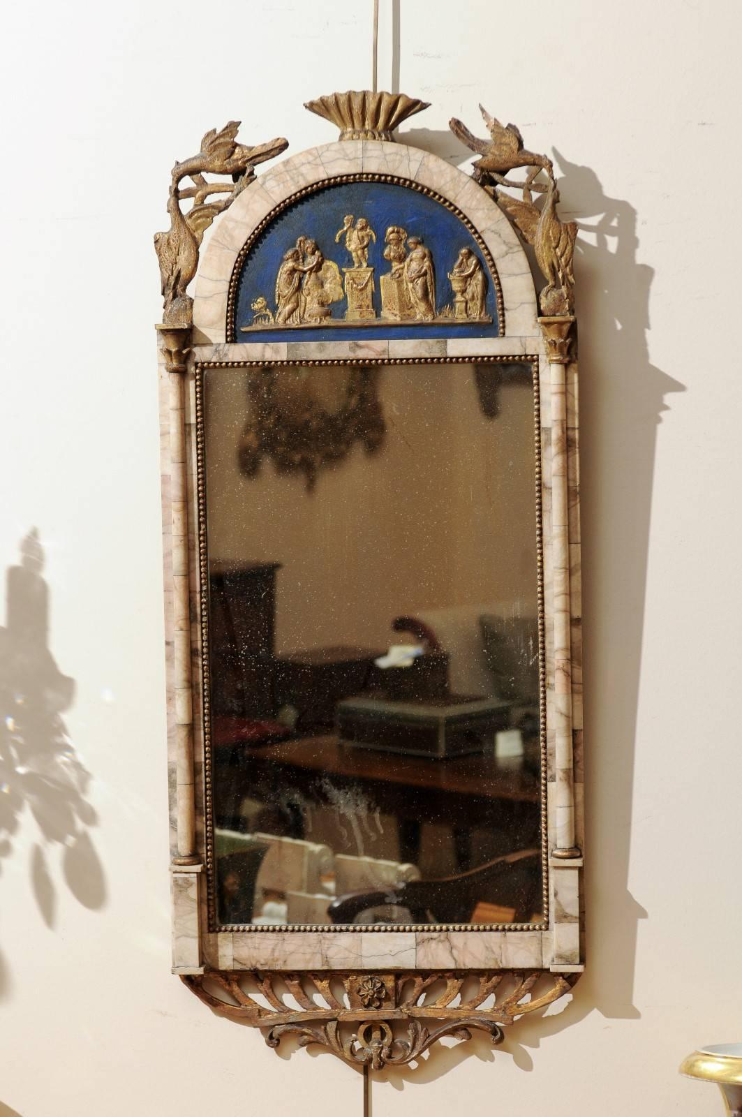 Spanish marble mounted mirror with gilt-wood carvings of birds resting on arched cornice with midnight blue ground with gilt Roman scene. Columns flanking mirror plate and pierced gilt-wood carving below. 
  
  
