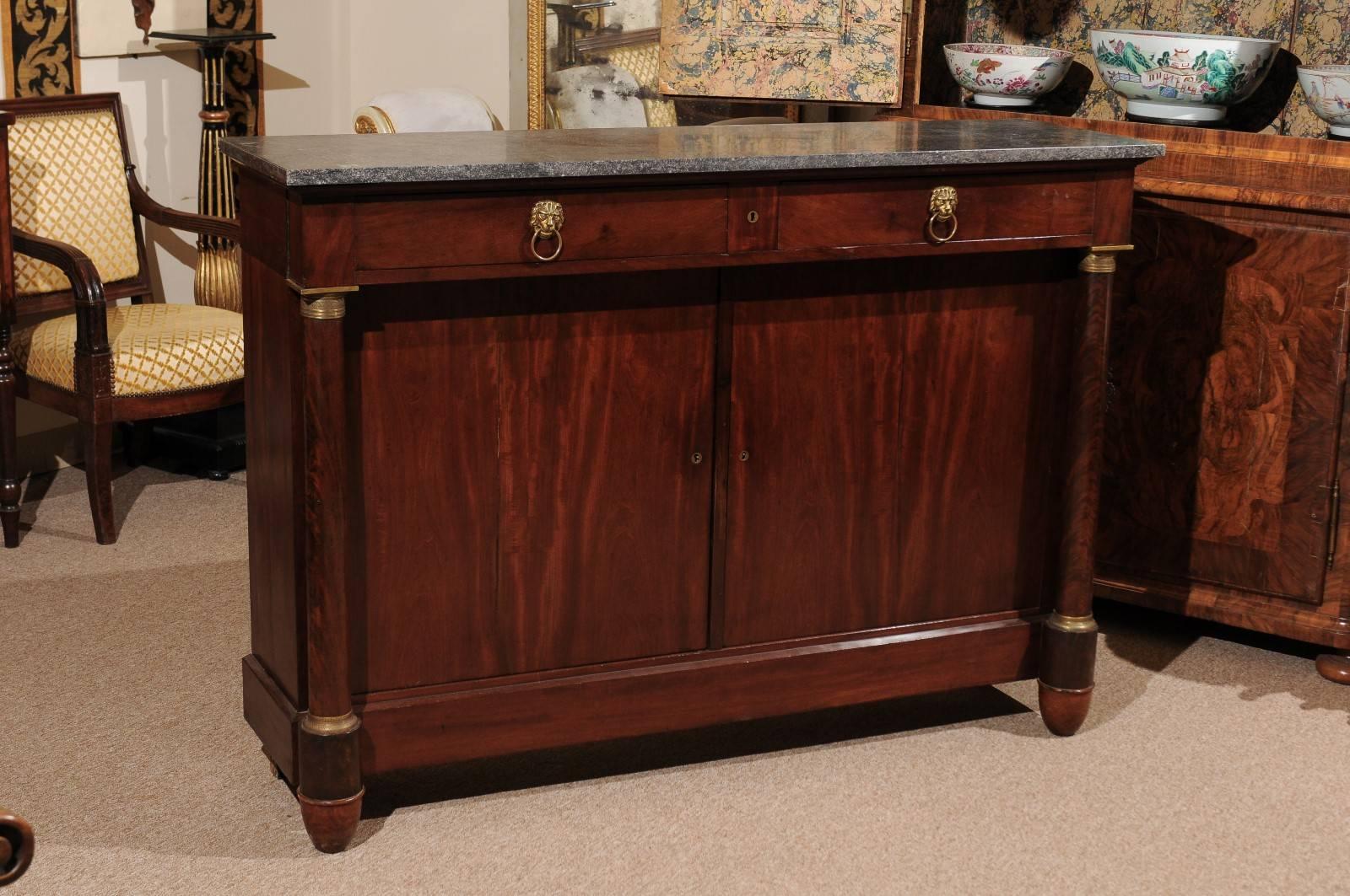 Empire mahogany buffet with two drawers above two cabinet doors, flanking columns with bronze doré mounts and grey marble top, France 19th century. Very narrow depth.