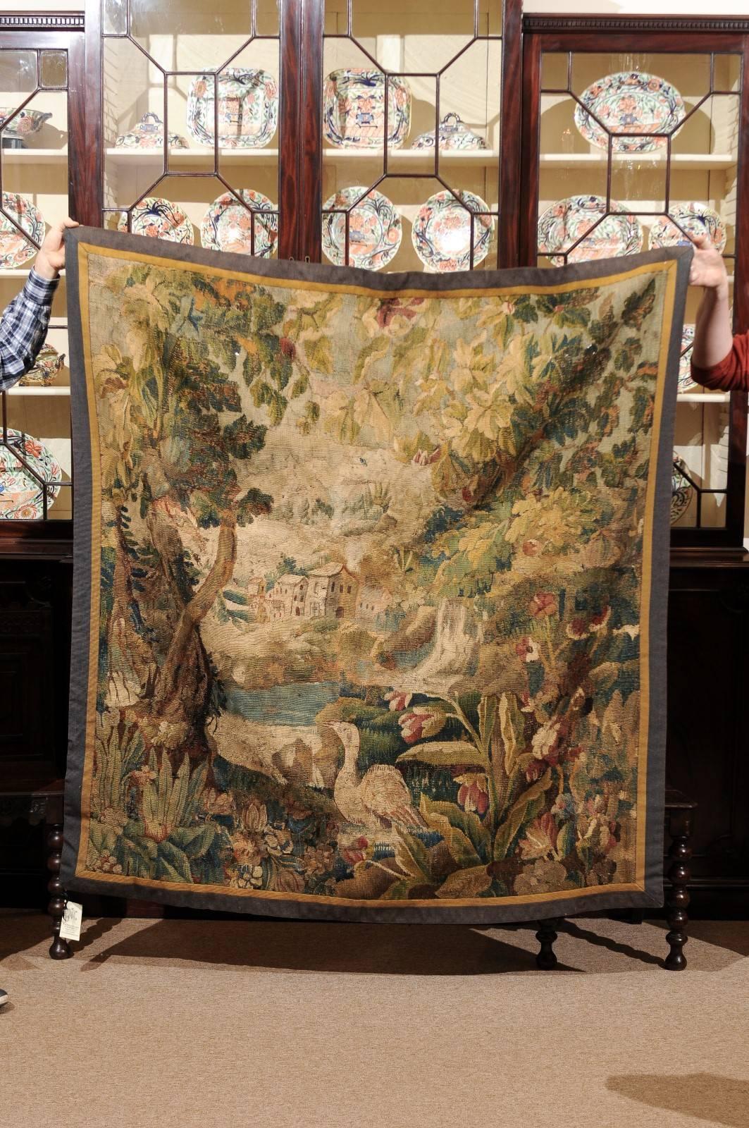 Aubusson French tapestry of village through the trees with bird, flowers and pond. The hues in soft green, blue, rose, tan and cream.