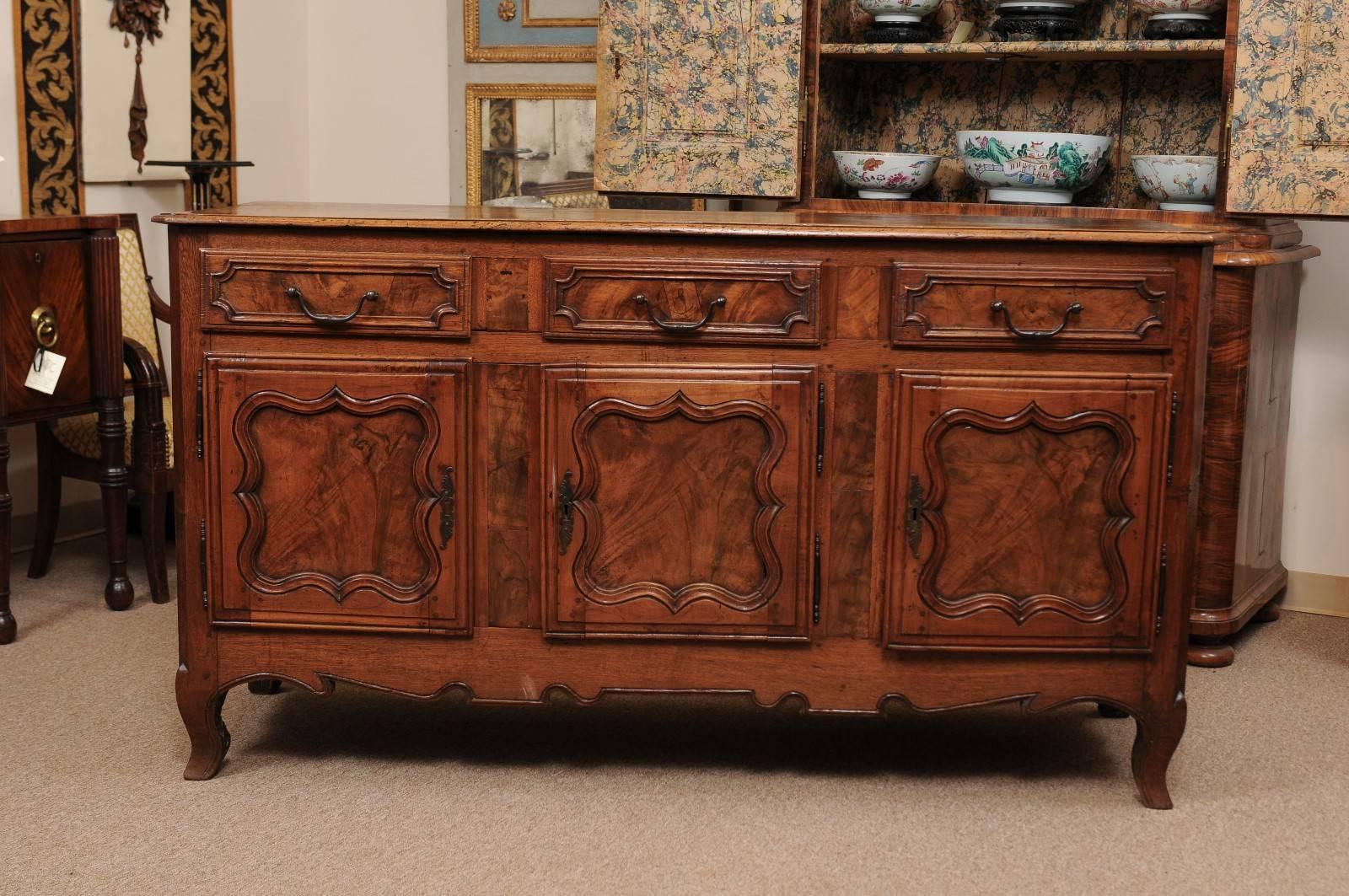 A mid 18th century French Louis XV walnut Enfilade featuring 3 drawers above 3 paneled cabinet doors with burled detail and shaped apron below ending on cabriole feet.