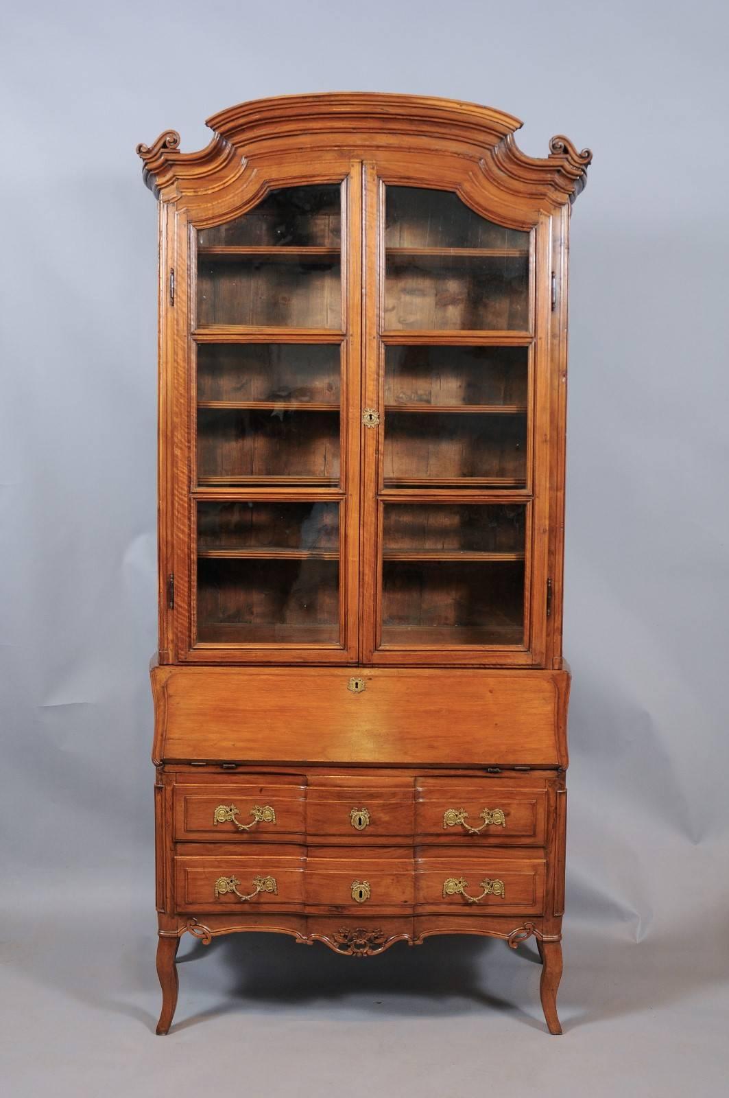 Mid-18th century Louis XV walnut tall bureau bookcase with carved arched cornice, glass panel doors and bureau below with writing surface, two drawers, pierced apron and cabriole legs.

 