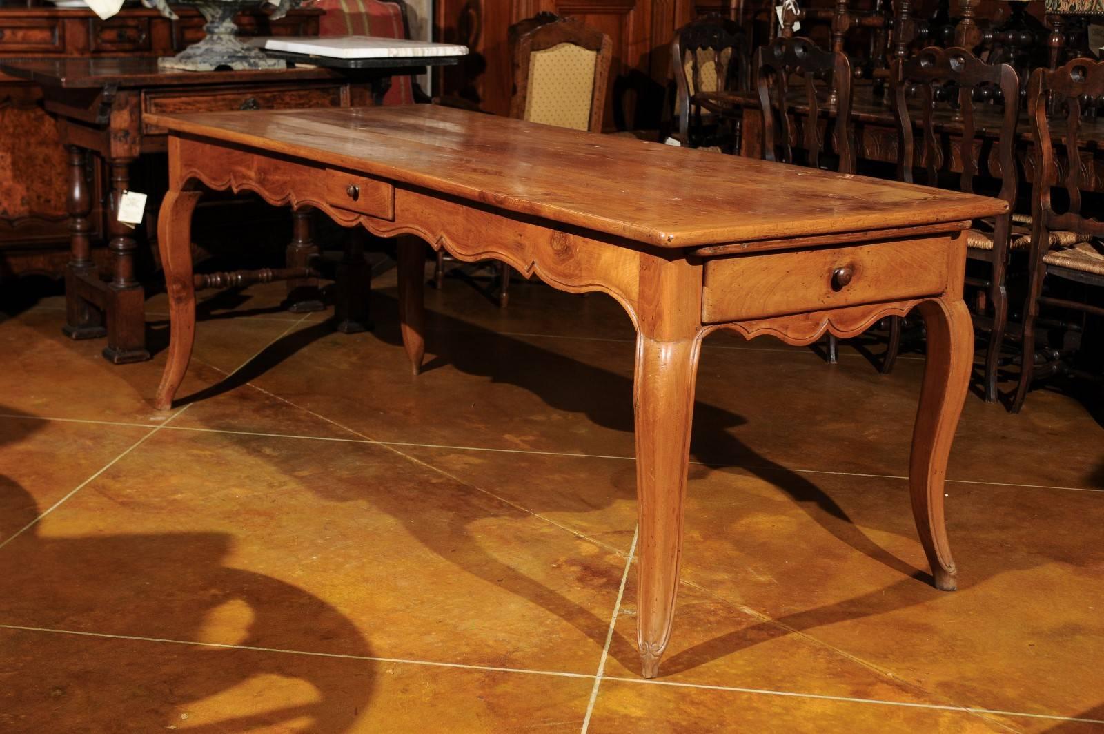 A turn of the 19th century French Fruitwood farm table with 2 drawers, shaped apron and cabriole legs.