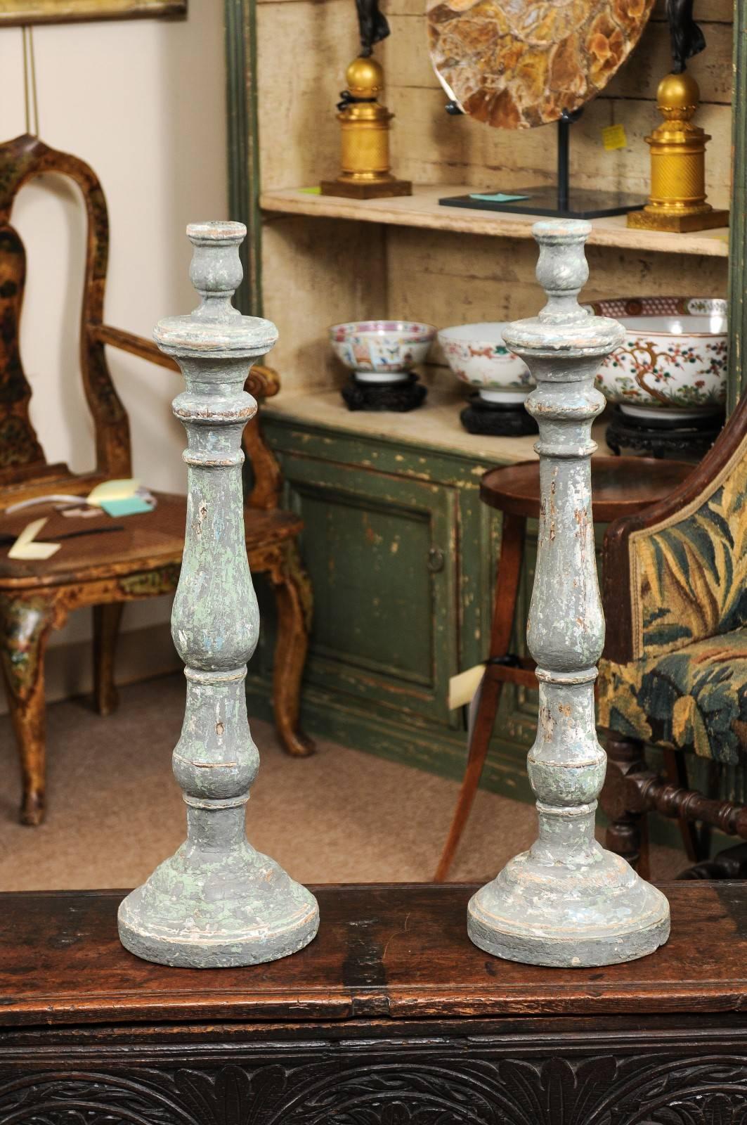 Pair of tall 19th century Italian carved wood candlesticks / altar sticks in distressed blue painted finish.