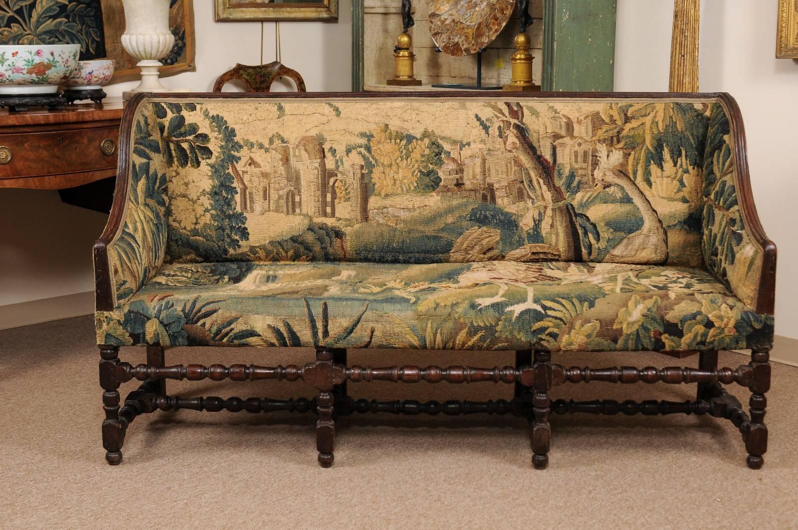 French Louis XIII style oak canape with 18th century Aubusson tapestry, wing sides, turned legs and stretcher.


 