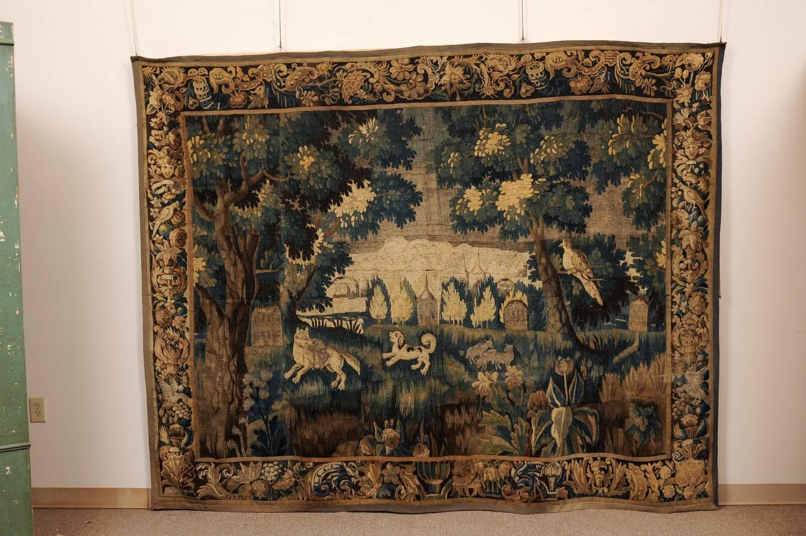 French Aubusson tapestry with dog hunt in landscape in green, blue, tan and brown hues. Retaining the original border.


 