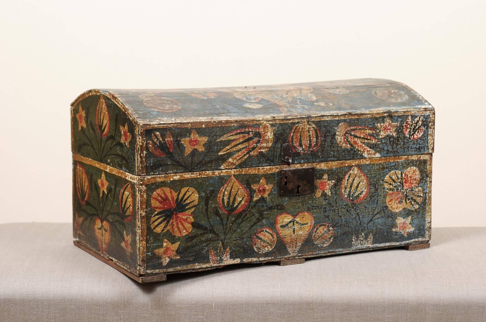 Large distressed blue-painted brides box featuring flower vase and bird decoration in orange-red and mustard hues, domed top and hinged lid, Sweden, 19th century. The back side of the box is unfinished.