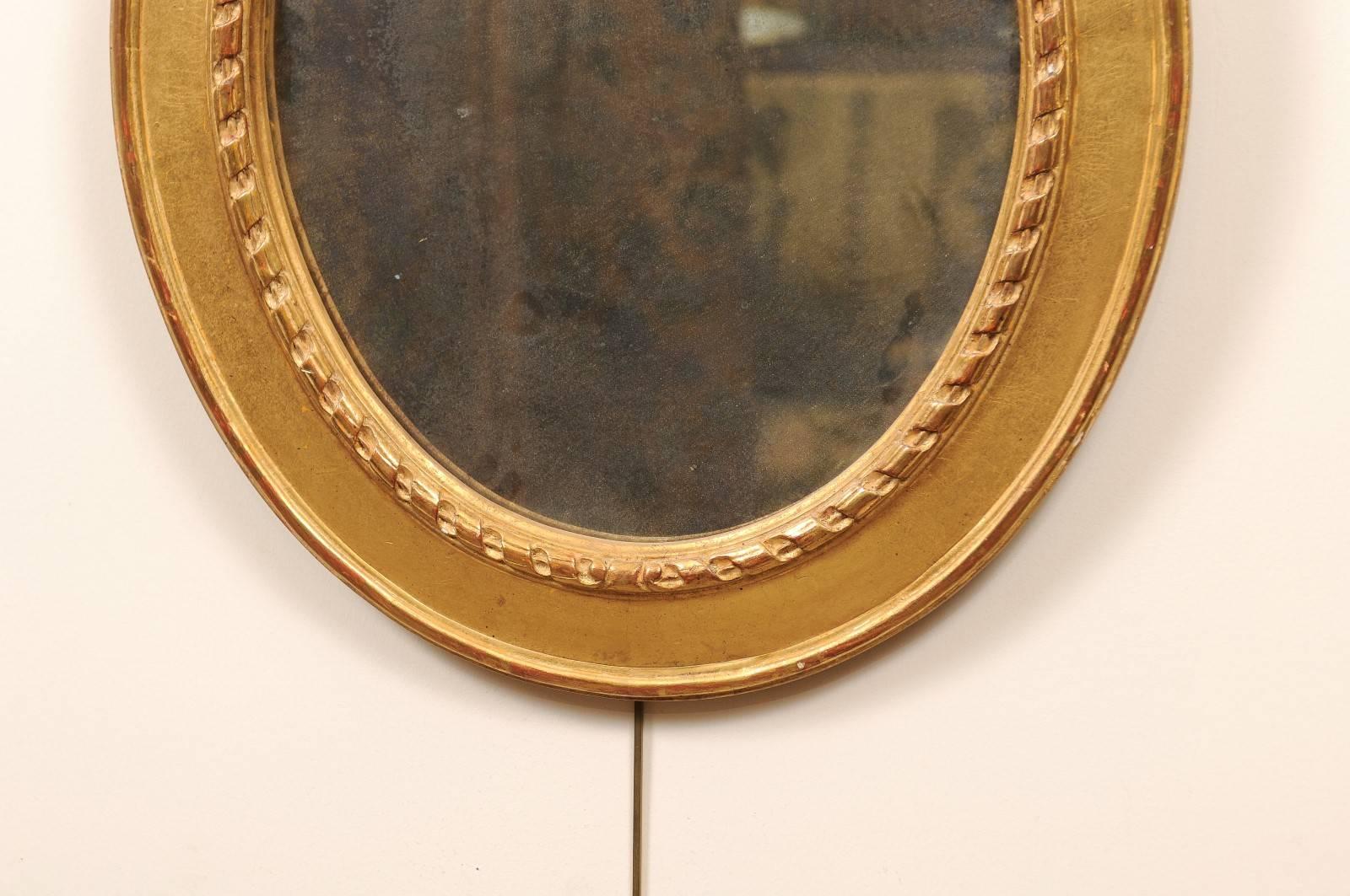 20ième siècle Paire de miroirs ovales en bois doré surmontés d'un nœud, 20ème siècle en vente