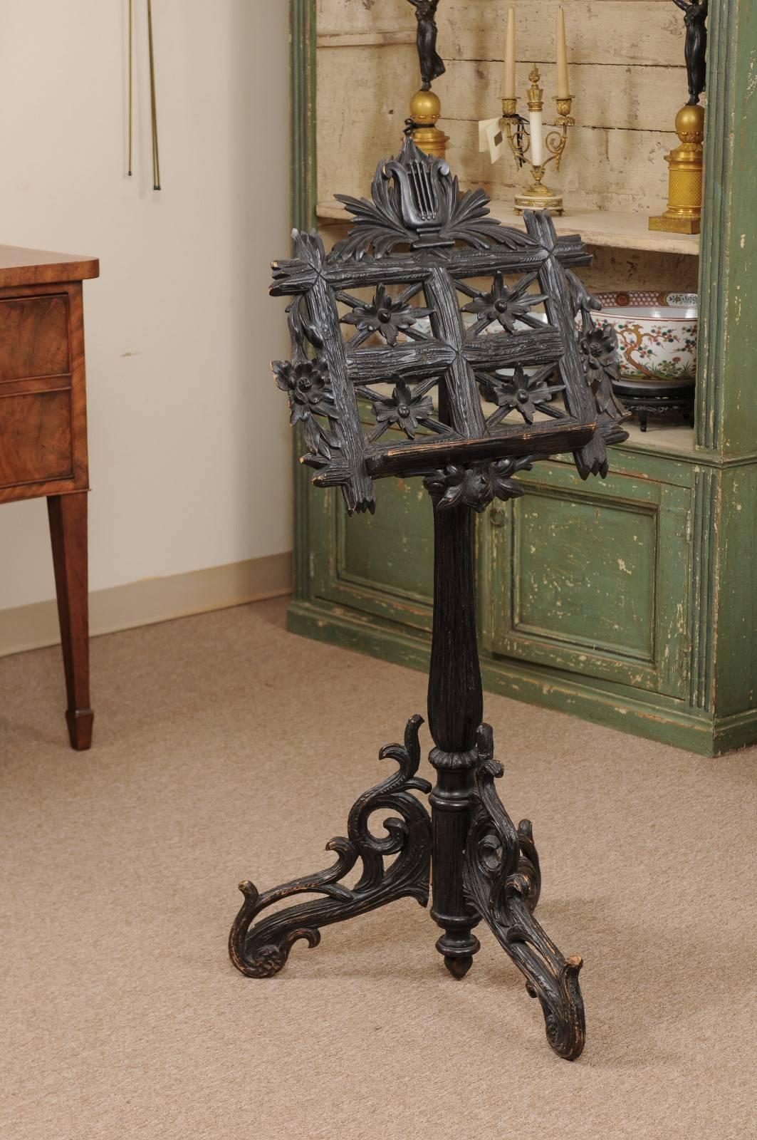 Carved Black Forest music sand with scroll decorated tripod base, lyre (music trophy) crest, and floral decoration, late 19th century, France.