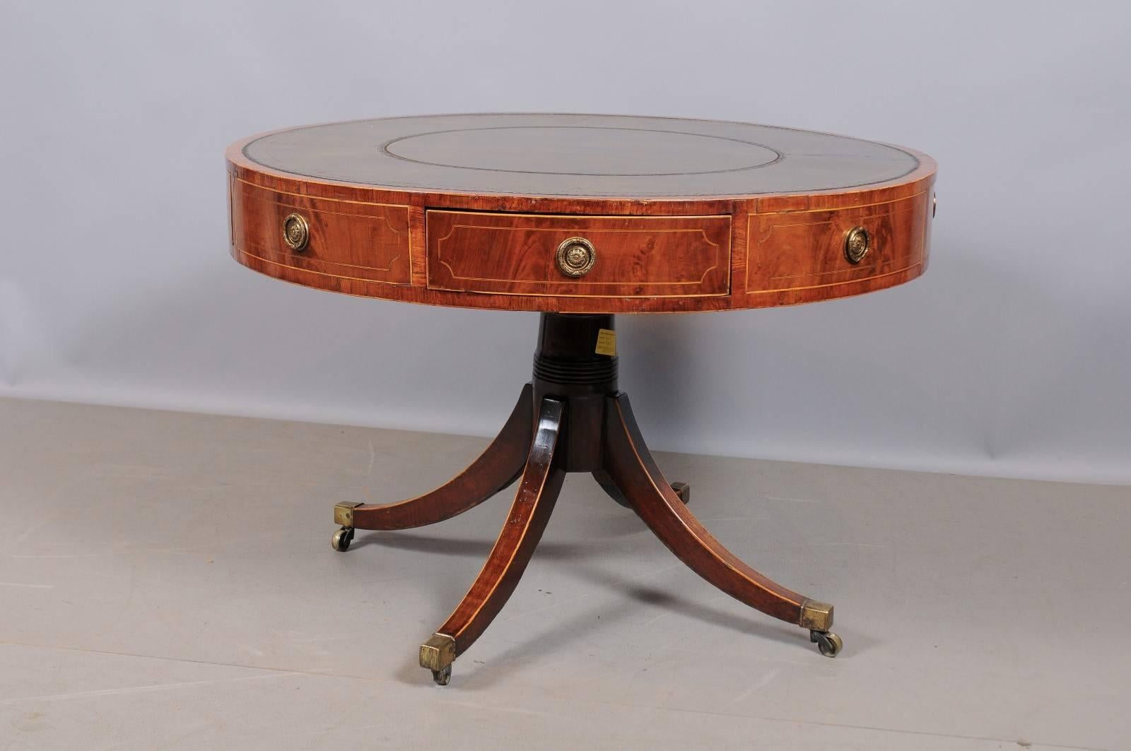 Early 19th century George III revolving mahogany drum table with inset green leather top, kings-wood cross-banding, string inlay, four working drawers, column base with four splayed legs on brass castors. 

William Word Fine Antiques, Atlanta's