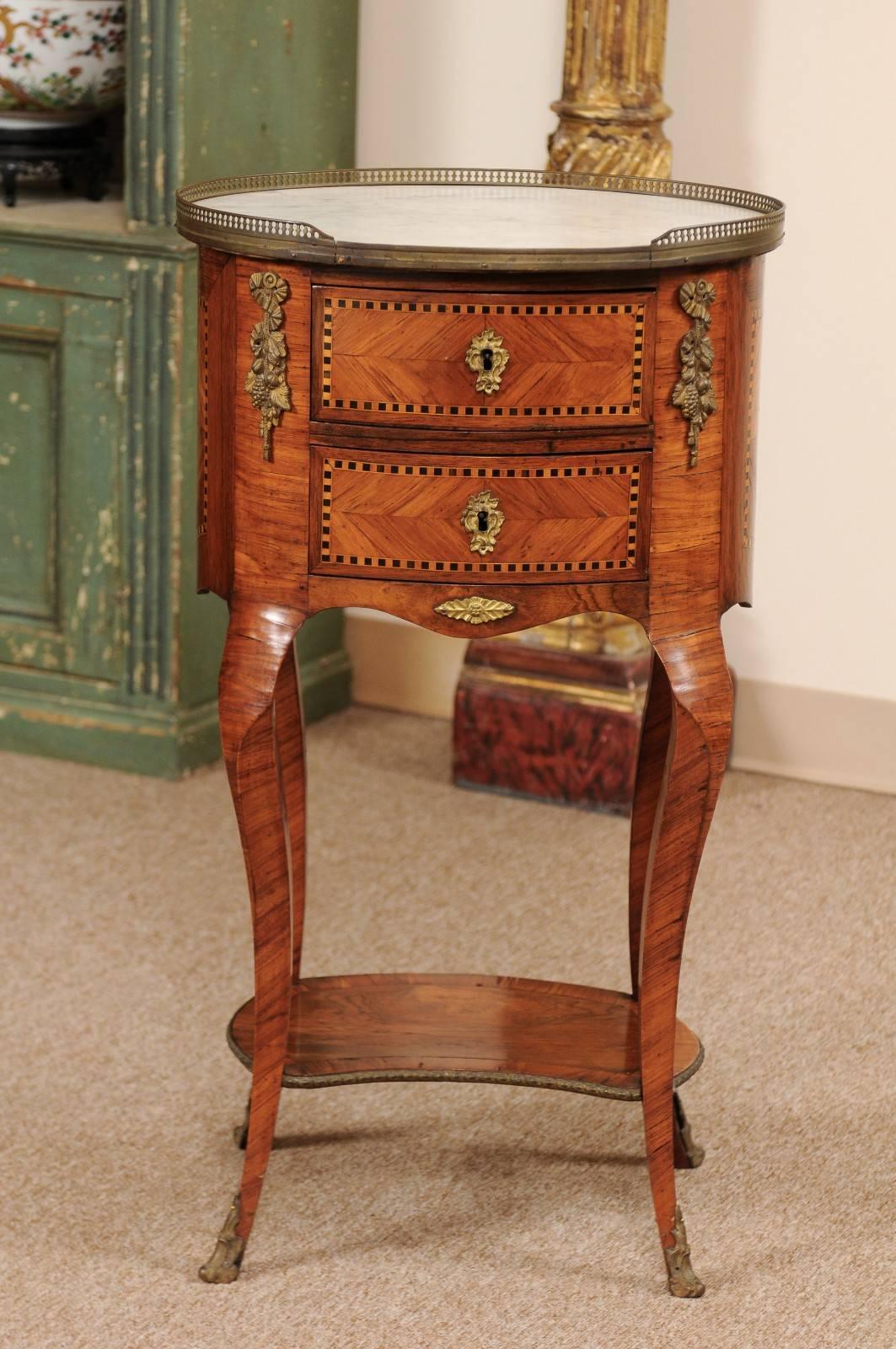 Oval-shaped inlaid tulipwood Chevet / bedside table with white marble top and gallery, ormolu mounts, two (2) drawers and lower shelf, and Cabriole legs, France, 19th century.