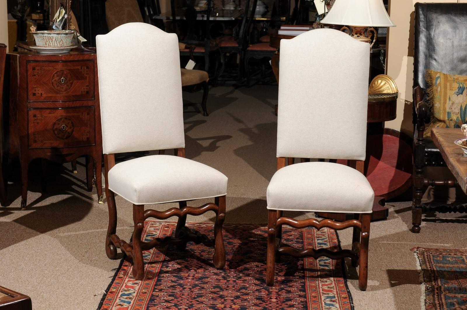 Louis XIV style set of eight "mutton bone" upholstered back dining chairs in oak with tall backs.