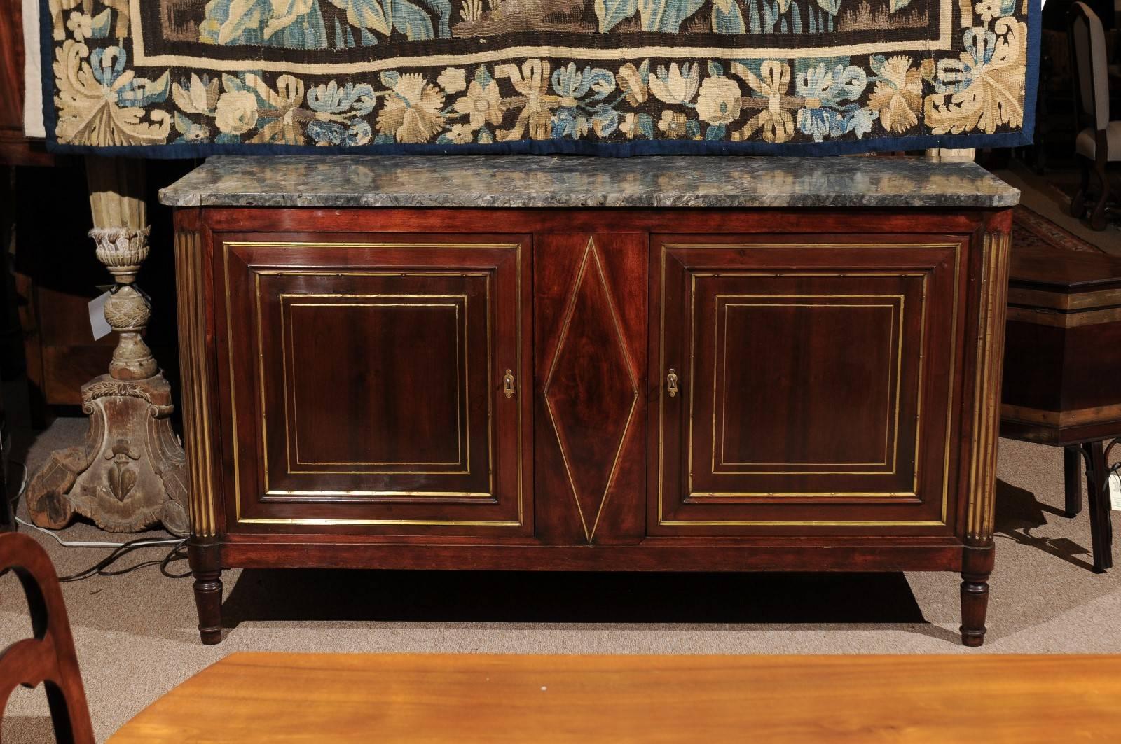 Directoire early 19th century, French mahogany buffet du Chasse with grey marble top and brass trim inlay. 


  