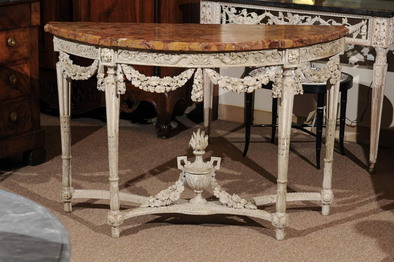 French 18th century Louis XVI period console in white painted finish with breche d' Alep marble top, laurel swag and urn carving, stretcher and fluted legs.

William Word Antiques: Atlanta's source for antique interiors since 1956.