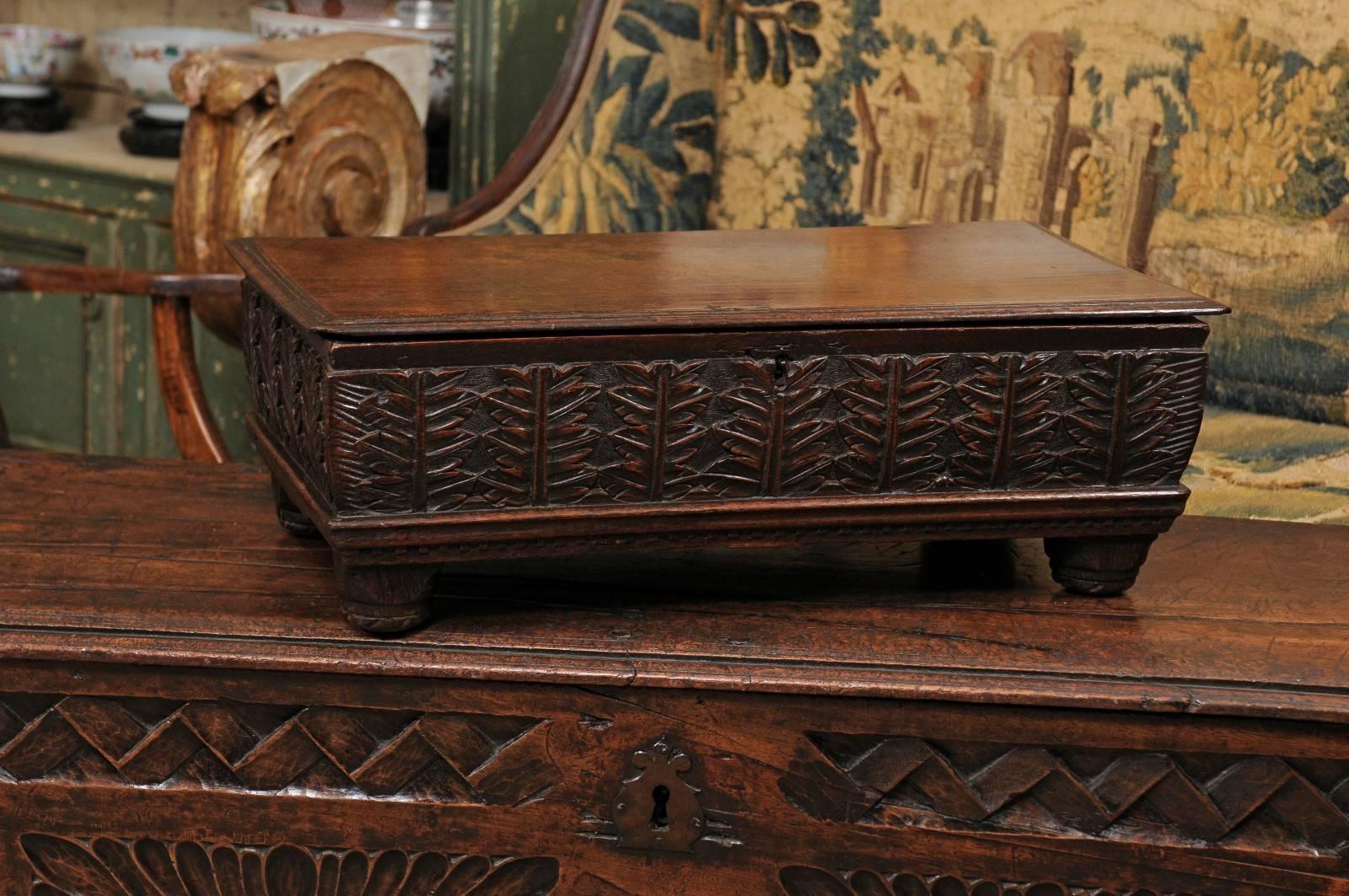 19th Century English oak bible box with foliate carving, tapered feet, & hinged lid.