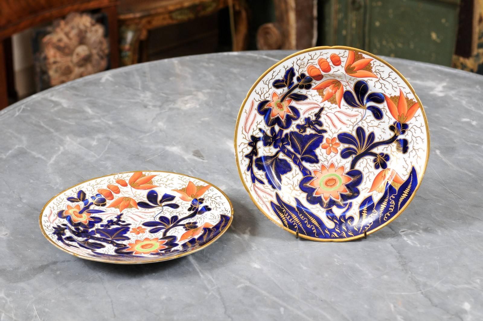 Paar große Teller aus Coalport-Porzellan mit vergoldetem Rand und Akzenten, Blumendekor in Blau-, Rot- und Grüntönen. 19. Jahrhundert England. Der Preis gilt für ein Paar Teller.