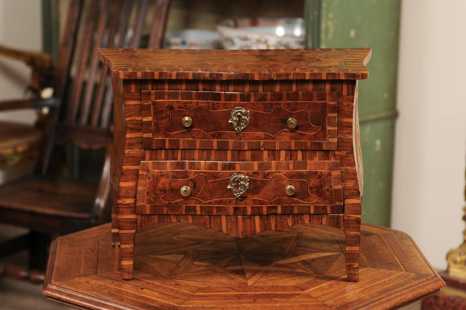Serpentine apprentice/sample sized commode in fruitwood, burled elm, and walnut with inlay, two-drawers, and cabriole legs, early 19th century, Italy.
