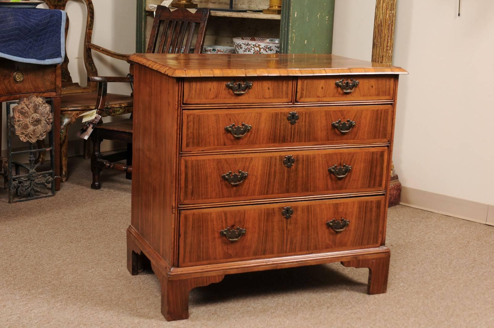 English early 18th century walnut chest with herringbone inlay, crossbanding, five drawers with brass pulls and all resting on shaped bracket feet. 

William Word Fine Antiques: Atlanta's source for antique interiors since 1956.