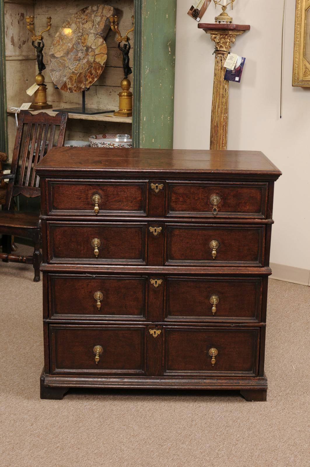 Jacobean style chest of drawers in oak with four graduated drawers featuring brass tear drop pulls, England, 18th century.