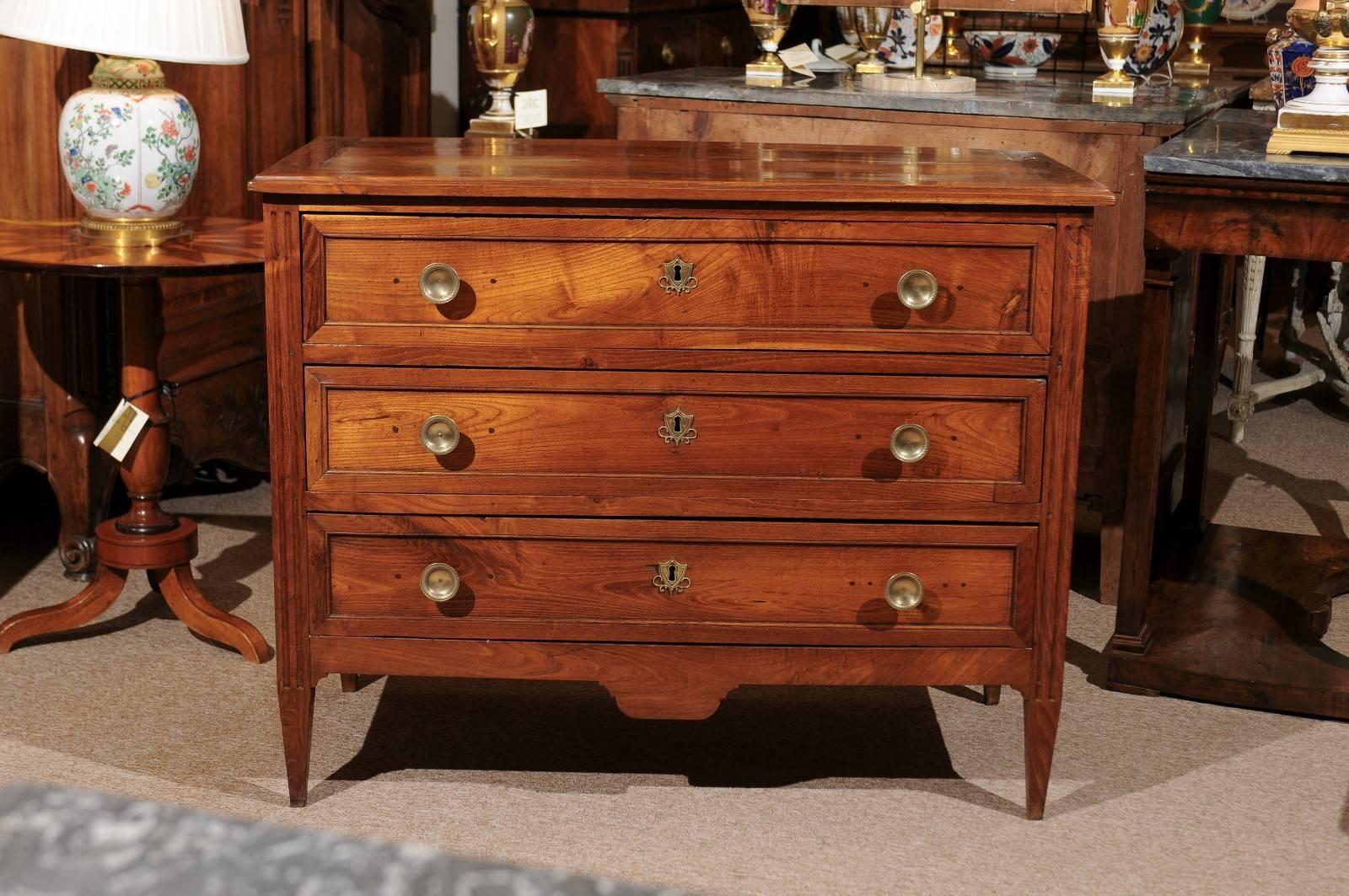 Early 19th century Directoire commode in elm with three drawers, brass pulls, shaped apron and square tapering legs.

William Word Fine Antiques: Atlanta's source for antique interiors since 1956.