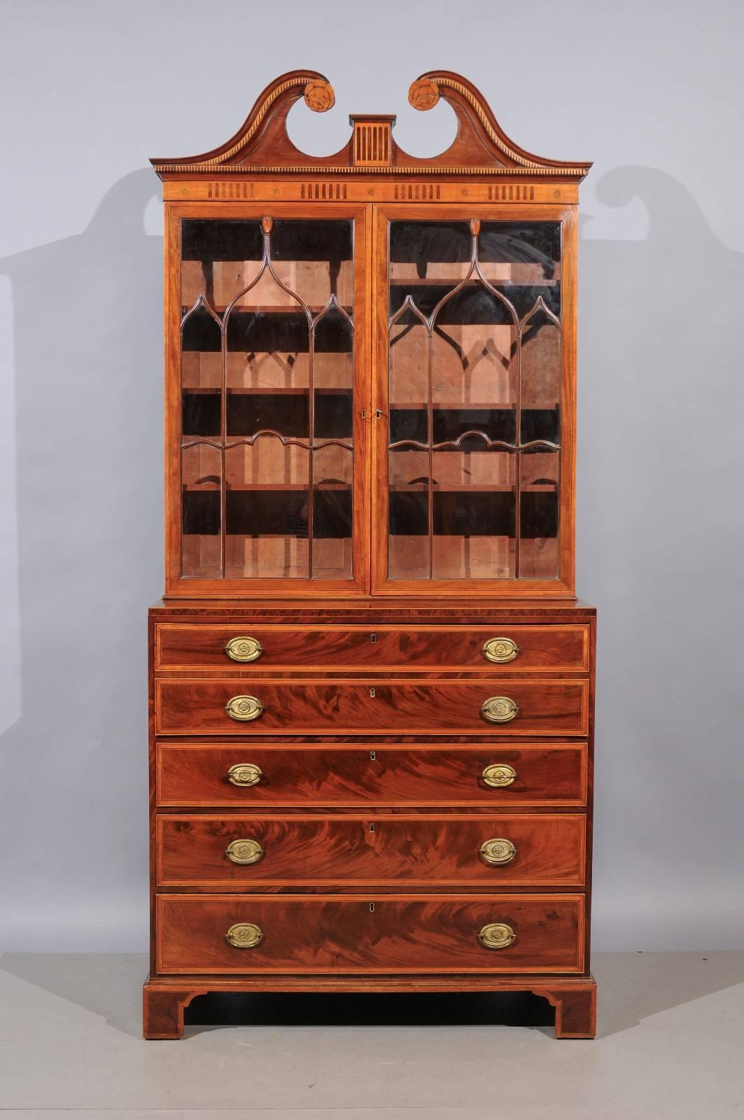 Early 19th century English George III inlaid secretary bookcase in mahogany and satinwood with two (2) glass front cabinet doors above and three (3) drawers and secretary drawer with fitted interior below, bracket feet, and swan neck pediment.