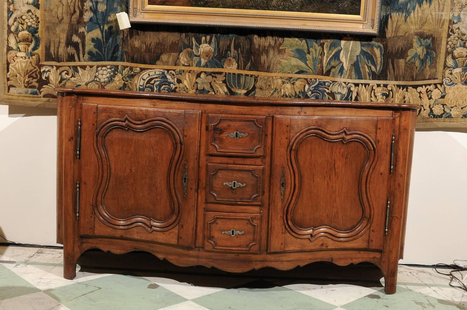 Louis XV Period Enfilade in oak with two cabinet doors flanking three central stacked drawers, shaped apron and serpentine front. France, 18th century. The wood on this piece is a faded oak with a medium brown tone.