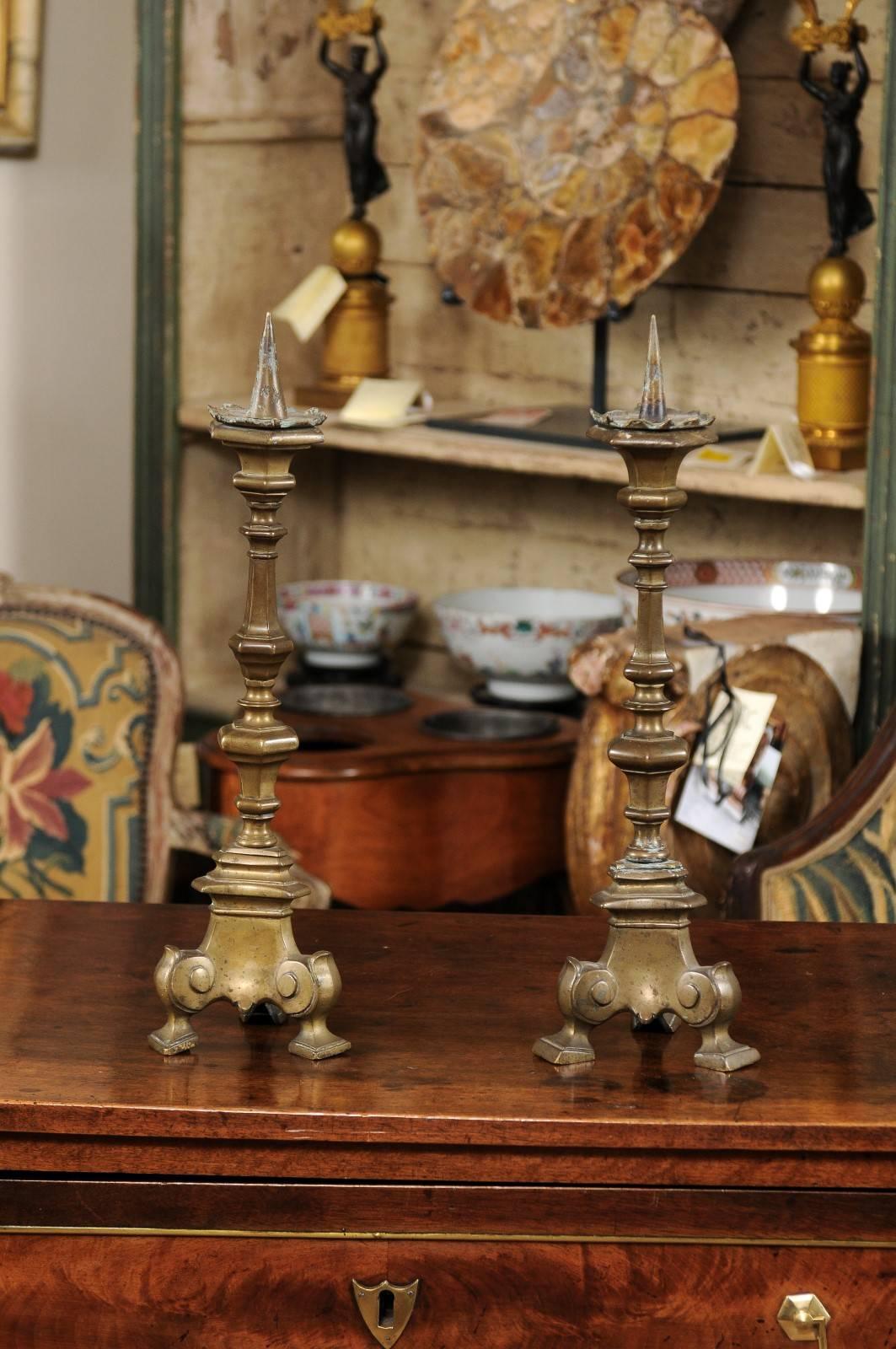 Pair of 17th century Italian brass candlesticks with scroll feet.