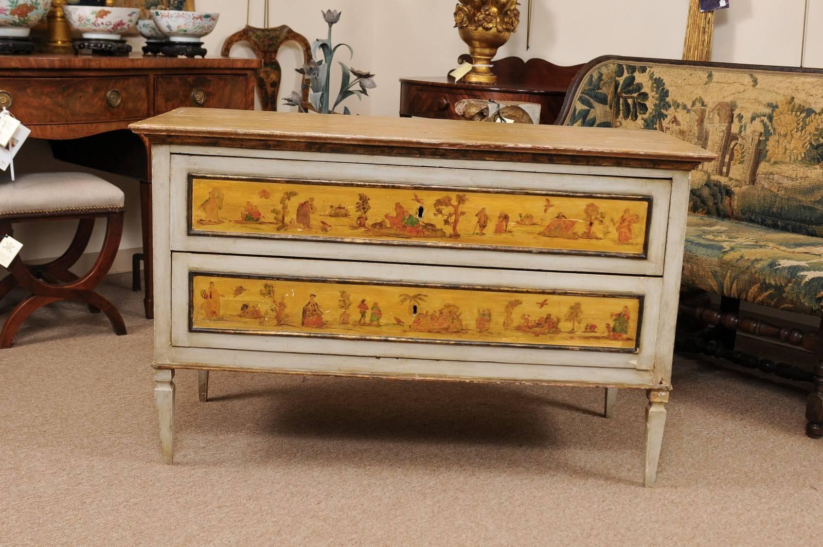 Neoclassical Italian early 19th century two-drawer commode with painted landscape scenes in blue grey and mustard hues, faux marble top and tapered legs. Key used for pulls.