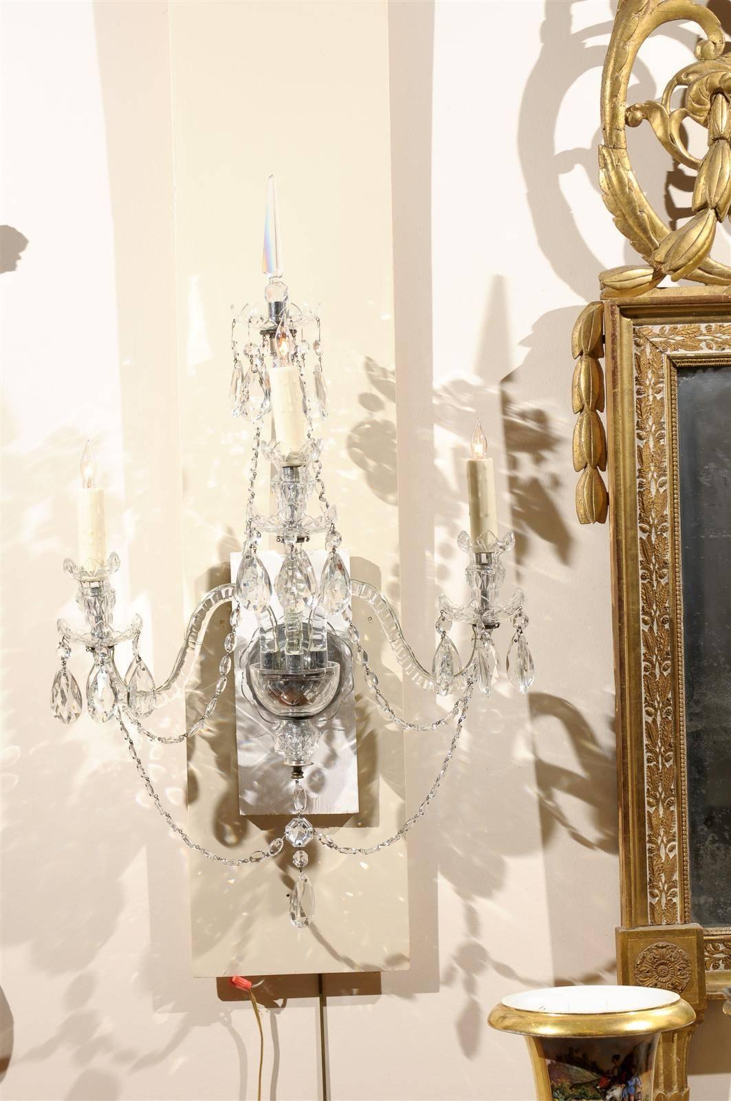 Pair of cut crystal arm sconces with three lights.