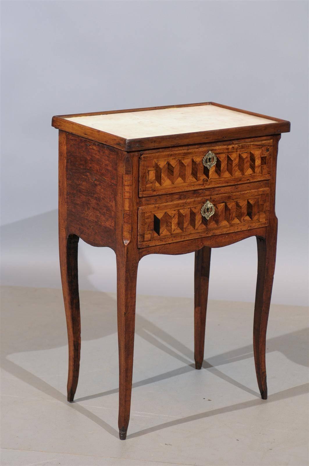 An 18th century French Louis XV chevet / side table with two drawers, parquetry inlay and white marble top. Dating from the second half of the 18th century and French in origin.