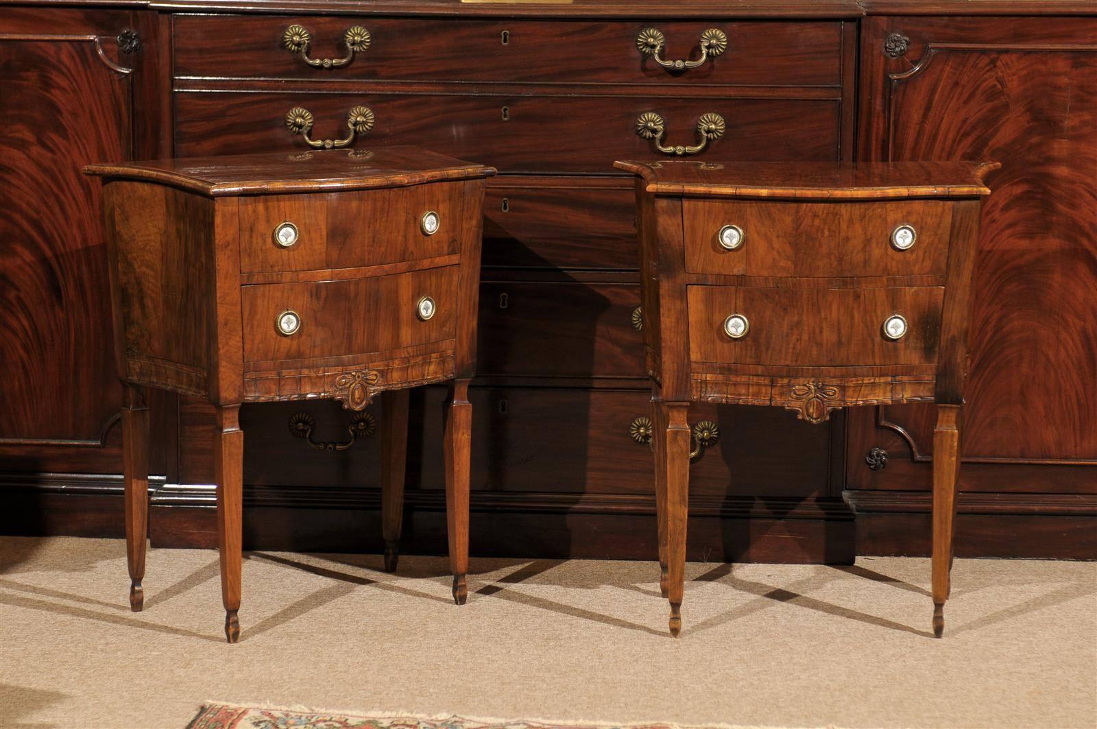 A pair of walnut bedside commodes with serpentine front & bow carving and tapered legs. 

