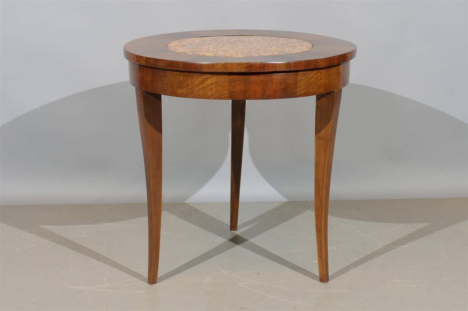 An Italian walnut gueridon with inset faux marble top.

