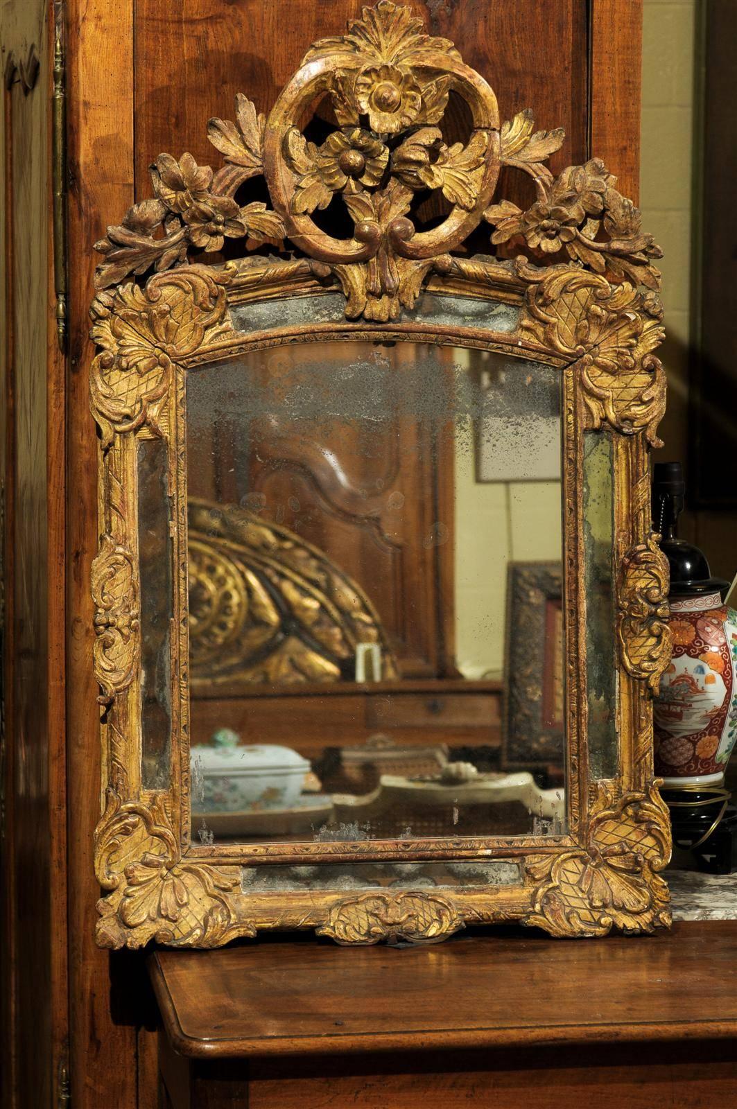 Early 18th century French transitional Regence/Louis XIV giltwood mirror with flower carving.